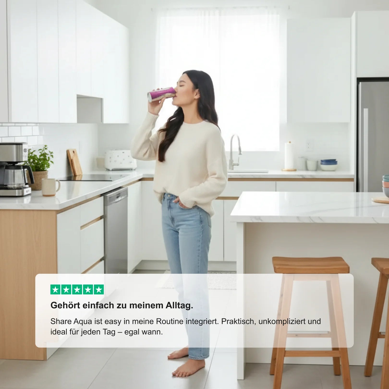 Frau trinkt ShareAqua d’Oro® in einer hellen Küche