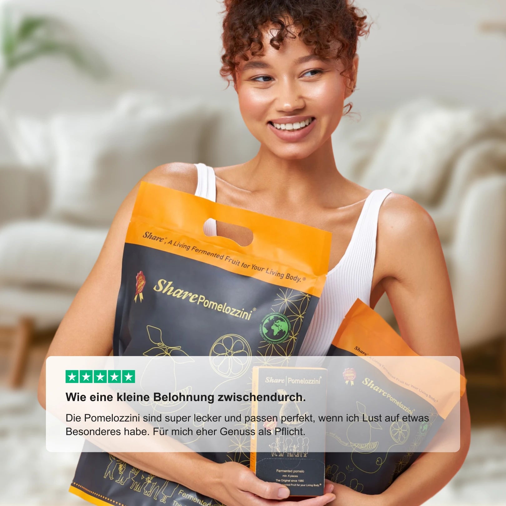 Zufriedene Kundin hält SharePomelozzini® Pralinen im Alltag – Genussmoment zu Hause